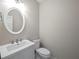 Powder room features an oval mirror, white vanity, and a standard toilet at 2138 Mill Garden Run, Buford, GA 30519