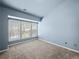This bedroom has blue walls, gray carpet and large windows at 2138 Mill Garden Run, Buford, GA 30519
