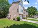 Townhome with a brick exterior, well-maintained lawn, and an attached garage at 2138 Mill Garden Run, Buford, GA 30519