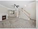 Bright living room with a fireplace, carpeted floors, staircase and open access to the kitchen area at 2138 Mill Garden Run, Buford, GA 30519