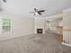 Cozy living room featuring a fireplace, ceiling fan, and a bright window at 2138 Mill Garden Run, Buford, GA 30519