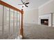 Open-concept living room featuring a fireplace, ceiling fan, and large windows for ample natural light at 2138 Mill Garden Run, Buford, GA 30519