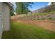 Lush backyard with retaining wall and wooden fence providing a private outdoor space at 2428 Mills Bnd, Decatur, GA 30034