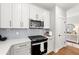 Well-lit kitchen featuring modern white cabinets, subway tile backsplash, and stainless steel appliances at 2428 Mills Bnd, Decatur, GA 30034