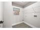 Clean, minimalist laundry room with tile flooring, wire shelving, and a welcome home sign at 2428 Mills Bnd, Decatur, GA 30034