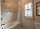 Clean bathroom with a shower-tub and a large window with shutter-style blinds at 3825 Valleyway Rd, Cumming, GA 30040