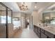 An elegant bathroom with double vanity, chandelier, and walk-in glass shower and tub at 3825 Valleyway Rd, Cumming, GA 30040