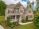 Beautiful two-story brick home with a manicured lawn, complimented by professional landscaping and a charming front porch at 3825 Valleyway Rd, Cumming, GA 30040