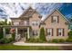 Charming brick two-story home with stone accents, shutters, manicured landscaping, and covered front porch at 3825 Valleyway Rd, Cumming, GA 30040