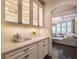Bright kitchen features stone countertops, glass cabinets, and is open to the well-lit living room at 3825 Valleyway Rd, Cumming, GA 30040