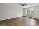 Spacious bedroom featuring wood-look floors, ceiling fan, and well-lit windows at 4657 Lou Ivy Rd, Peachtree Corners, GA 30096