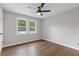 Bright bedroom featuring wood-look floors, a modern ceiling fan, and neutral paint at 4657 Lou Ivy Rd, Peachtree Corners, GA 30096
