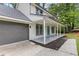 View of the home and attached garage, complete with a covered porch and cheerful blue front door at 4657 Lou Ivy Rd, Peachtree Corners, GA 30096