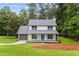 Charming home with a blue front door, a gray roof, and a freshly landscaped lawn at 4657 Lou Ivy Rd, Peachtree Corners, GA 30096