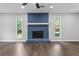 Bright living room with a blue painted stone fireplace and modern ceiling fan at 4657 Lou Ivy Rd, Peachtree Corners, GA 30096