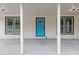 Covered front porch has updated fixtures and an inviting blue front door, perfect for relaxing outdoors at 4657 Lou Ivy Rd, Peachtree Corners, GA 30096