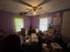 A bedroom filled with boxes and items, featuring a ceiling fan and natural light from two windows at 6722 Heardsville Rd, Cumming, GA 30028