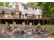 Landscaped backyard with a stone fire pit area, seating, and an elevated wooden deck at 5322 Seaton Dr, Atlanta, GA 30338