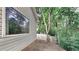 Exterior view of house with a large window and a wooded area beyond a fence at 700 Patriots Point St, Locust Grove, GA 30248