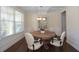 Well-lit dining room featuring hardwood floors, a modern chandelier, and a round wooden table set for four at 126 Oakleigh Pointe Dr, Dallas, GA 30157