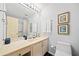Well-lit bathroom with a single sink vanity, framed art and shower-tub combo at 1260 Willeo Creek Dr, Roswell, GA 30075