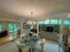 Open dining room with glass table and chandelier; view into sitting area with bright windows at 1260 Willeo Creek Dr, Roswell, GA 30075