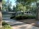 View of the home's exterior with an attached garage and a long driveway, surrounded by mature trees at 1260 Willeo Creek Dr, Roswell, GA 30075