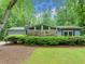 Ranch-style home featuring large windows, stone accents, and a well-manicured lawn at 1260 Willeo Creek Dr, Roswell, GA 30075