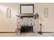 Stone fireplace with wooden mantle, decorated with ornate sconces and a framed mirror at 1260 Willeo Creek Dr, Roswell, GA 30075