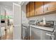 Modern laundry room with stainless steel appliances and wooden cabinets for convenience at 1260 Willeo Creek Dr, Roswell, GA 30075