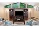 Inviting living room featuring large windows, a stone fireplace, and dark wood entertainment center at 1260 Willeo Creek Dr, Roswell, GA 30075
