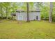 Grassy backyard with mature trees and a patio, providing a scenic and peaceful outdoor space at 3084 Fern Valley Sw Dr, Marietta, GA 30008