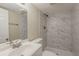 Bathroom with white marble tiles, sink, shower, and toilet, well lit by overhead lighting at 3084 Fern Valley Sw Dr, Marietta, GA 30008