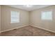 A well-lit bedroom with two windows, plush carpeting, and neutral walls at 3084 Fern Valley Sw Dr, Marietta, GA 30008