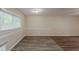 An open room with grey wood floors, white trim, and a large window at 3084 Fern Valley Sw Dr, Marietta, GA 30008