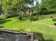 Expansive backyard with lush green grass, mature trees, and brick-lined garden beds at 3662 Greentree Farms Dr, Decatur, GA 30034