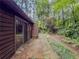 Backyard patio with a stone pathway leading to an overgrowth of trees at 3835 Shawnee Sw Run, Lilburn, GA 30047