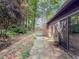 Backyard patio with a stone pathway leading to a variety of lush plants and trees at 3835 Shawnee Sw Run, Lilburn, GA 30047