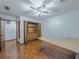 Bedroom featuring wood floors, ceiling fan, built-ins, and access to additional rooms at 3835 Shawnee Sw Run, Lilburn, GA 30047