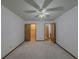 An open bedroom with a ceiling fan, neutral carpet, and natural wood doors at 3835 Shawnee Sw Run, Lilburn, GA 30047