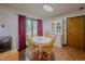 Bright dining room features wood floors, white table and chairs, and sliding glass door at 3835 Shawnee Sw Run, Lilburn, GA 30047