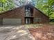 Home with garage and second story balcony in wooded setting at 3835 Shawnee Sw Run, Lilburn, GA 30047