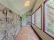 Bright hallway featuring a stone wall, wood floors, multiple windows, and natural light at 3835 Shawnee Sw Run, Lilburn, GA 30047