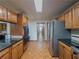 Spacious kitchen features wood cabinets, granite countertops and stainless steel refrigerator at 3835 Shawnee Sw Run, Lilburn, GA 30047