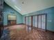 Cozy living room with fireplace, parquet floors, and shuttered doors to the patio at 3835 Shawnee Sw Run, Lilburn, GA 30047