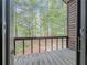 Outdoor porch with wood flooring and railing featuring views of lush green trees at 3835 Shawnee Sw Run, Lilburn, GA 30047