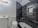 Modern shower with dark marbled tile, built in shelving and a rain shower head at 3835 Shawnee Sw Run, Lilburn, GA 30047
