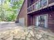 Side view of the home featuring a stone patio and spacious driveway at 3835 Shawnee Sw Run, Lilburn, GA 30047