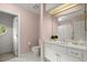 Charming bathroom with dual sinks, white cabinetry, and a round window in the adjacent toilet room at 40 Ivy Chase Ne, Atlanta, GA 30342