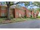 Beautiful red brick townhome with manicured landscaping and a charming front entrance with mature trees at 40 Ivy Chase Ne, Atlanta, GA 30342